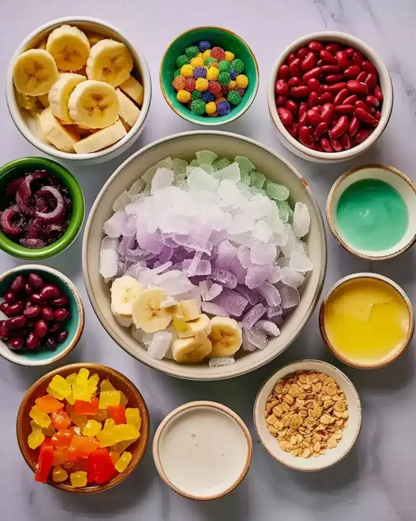Filipino dessert halo halo ingredients including shaved ice, ube halaya, coconut jelly, and tropical fruits arranged in bowls